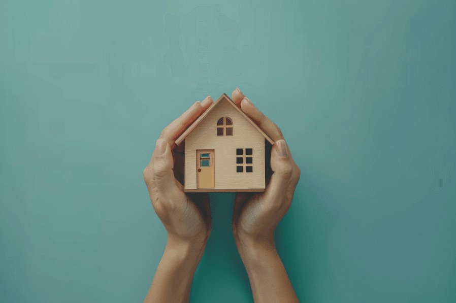 A model home being held by two hands.