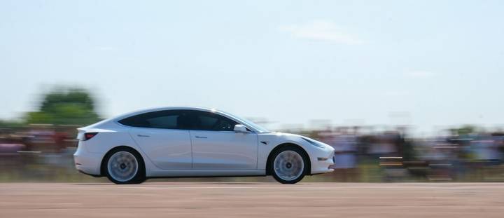 Tesla Model 3 compact sedan driving in New Zealand featured in a Tesla car insurance 2026 guide to premiums by Quashed.