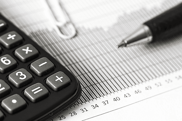 Close-up of a black calculator and a pen resting on a financial document with a bar chart, used for calculating 2026 Southern Cross Health Insurance premiums.