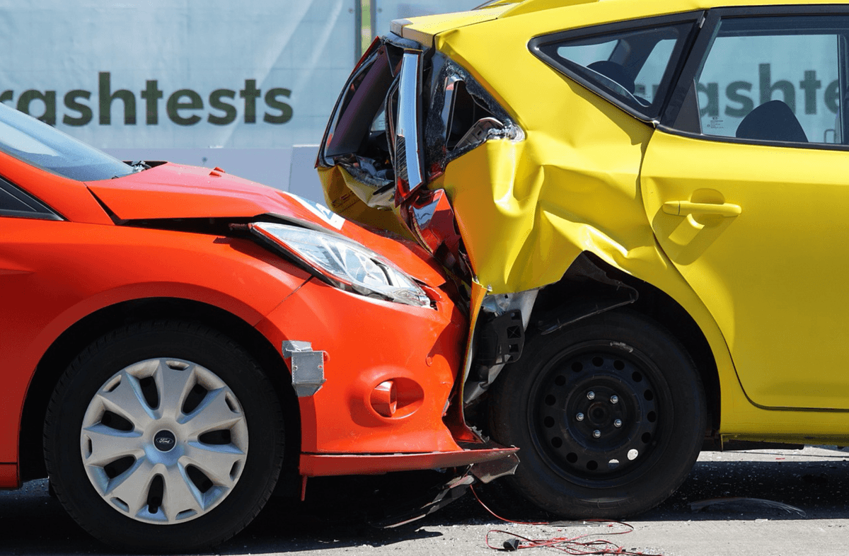 A rear end car accident between a red and yellow car.