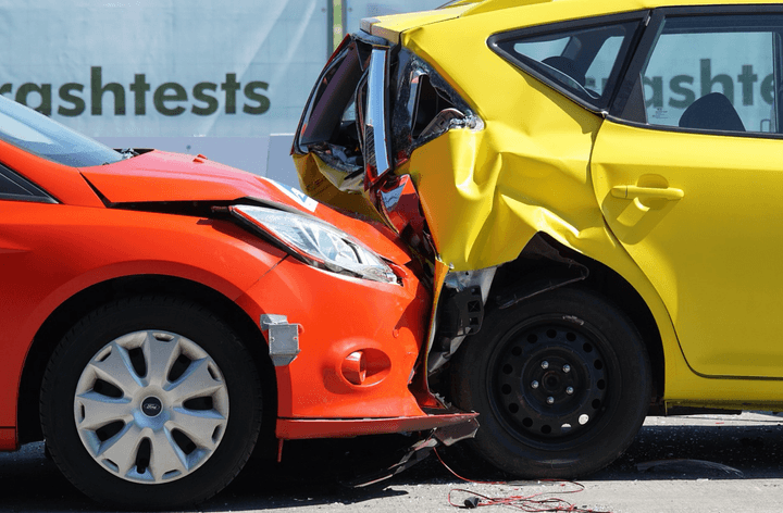 A rear end car accident between a red and yellow car.
