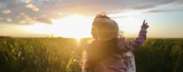walking towards the sunset in a field