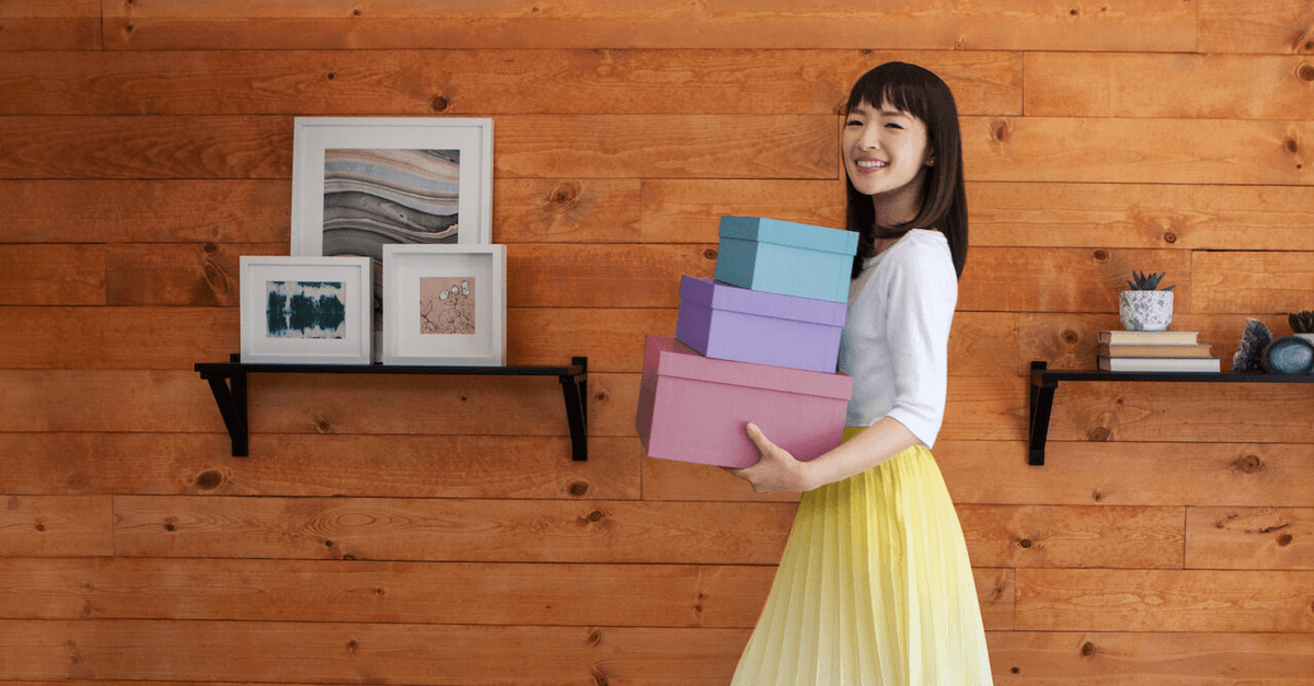 A woman holding three boxes.