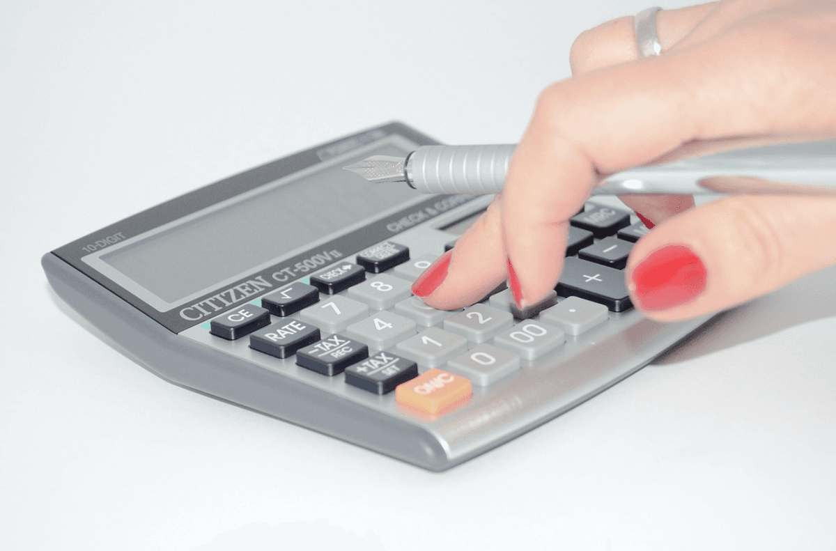 New Zealand homeowner using a calculator to estimate total contents value for insurance in 2025.