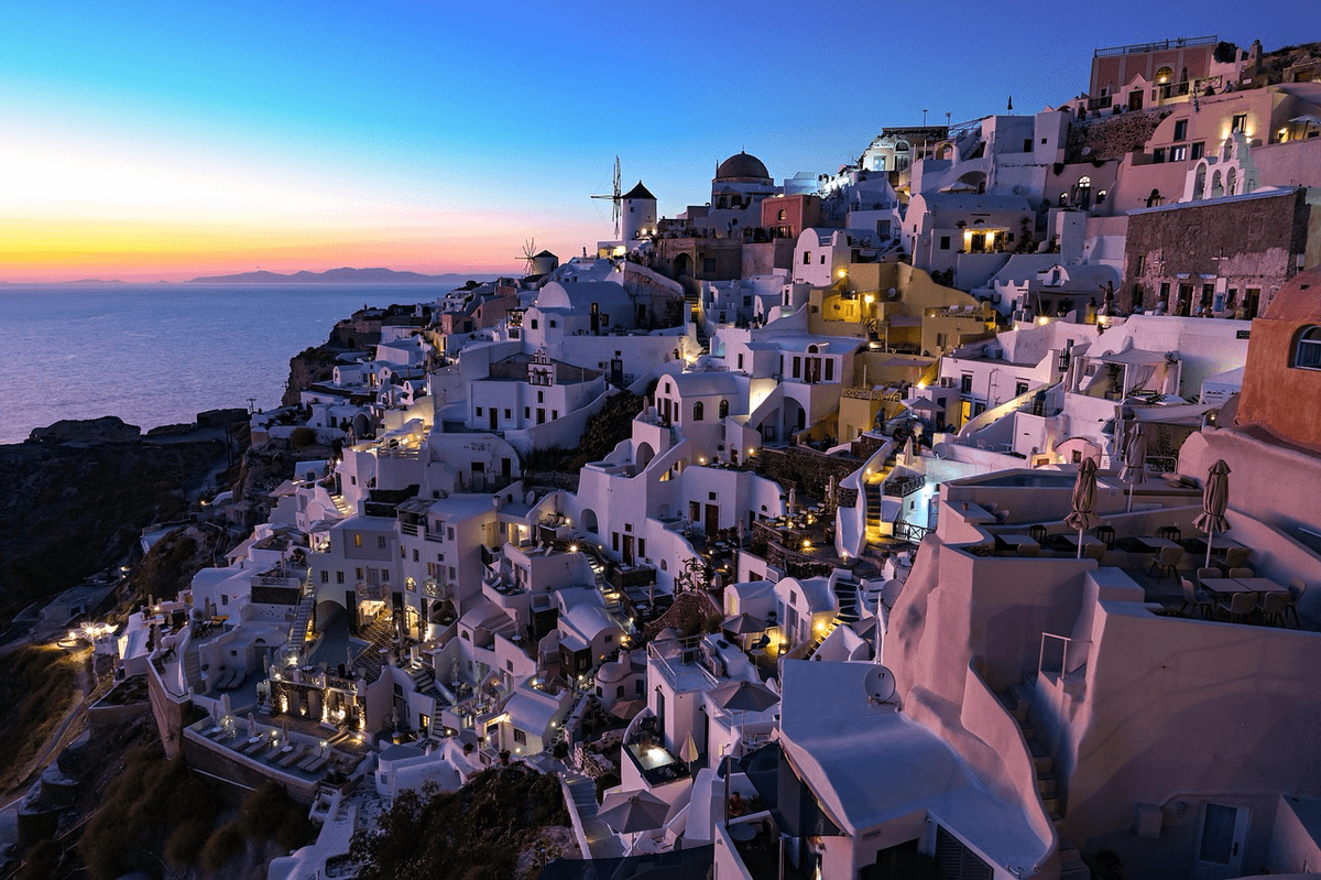 Scenic view of a Mediterranean village at sunset, highlighting the importance of securing the best travel insurance for Kiwis in 2026 with a Quashed Market Scan.