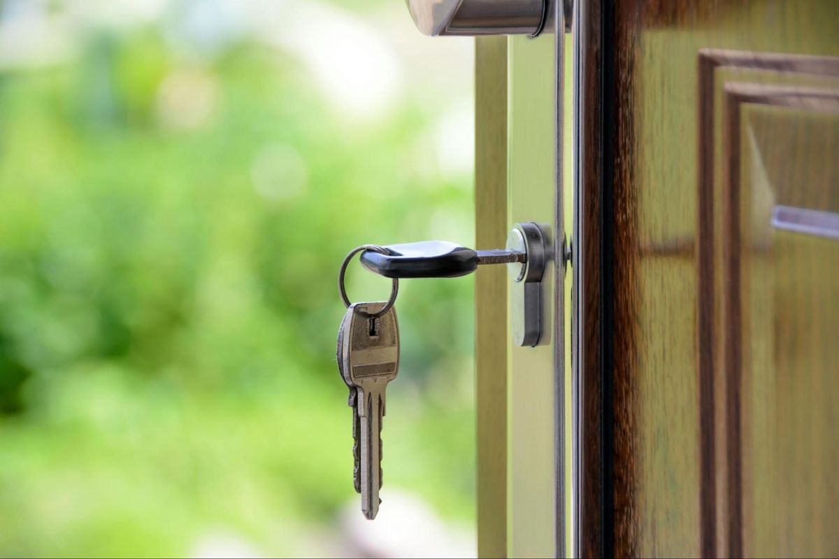 A set of house keys in a door lock, representing homeowners choosing between Sum Insured and Area Replacement cover in 2026 by Quashed