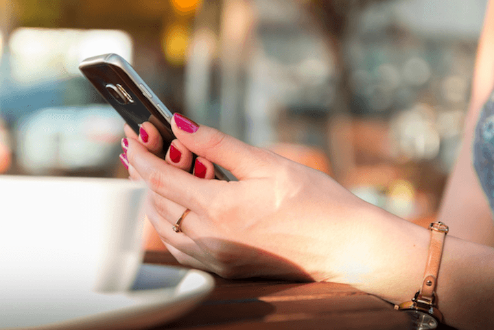 A person using a smartphone to check fuel prices on an app, representing how Kiwi drivers are using crowd-sourced tools like Gaspy to find the cheapest petrol stations during the 2026 fuel crisis.