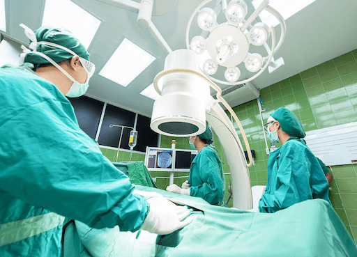 A surgical team in green scrubs performing a procedure in a hospital operating room, featured in the 2026 Quashed review of Southern Cross Health Insurance. 